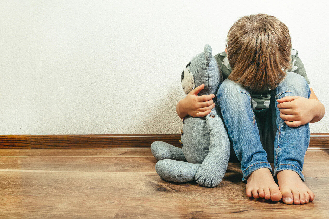 Sad depressed boy with teddy bear